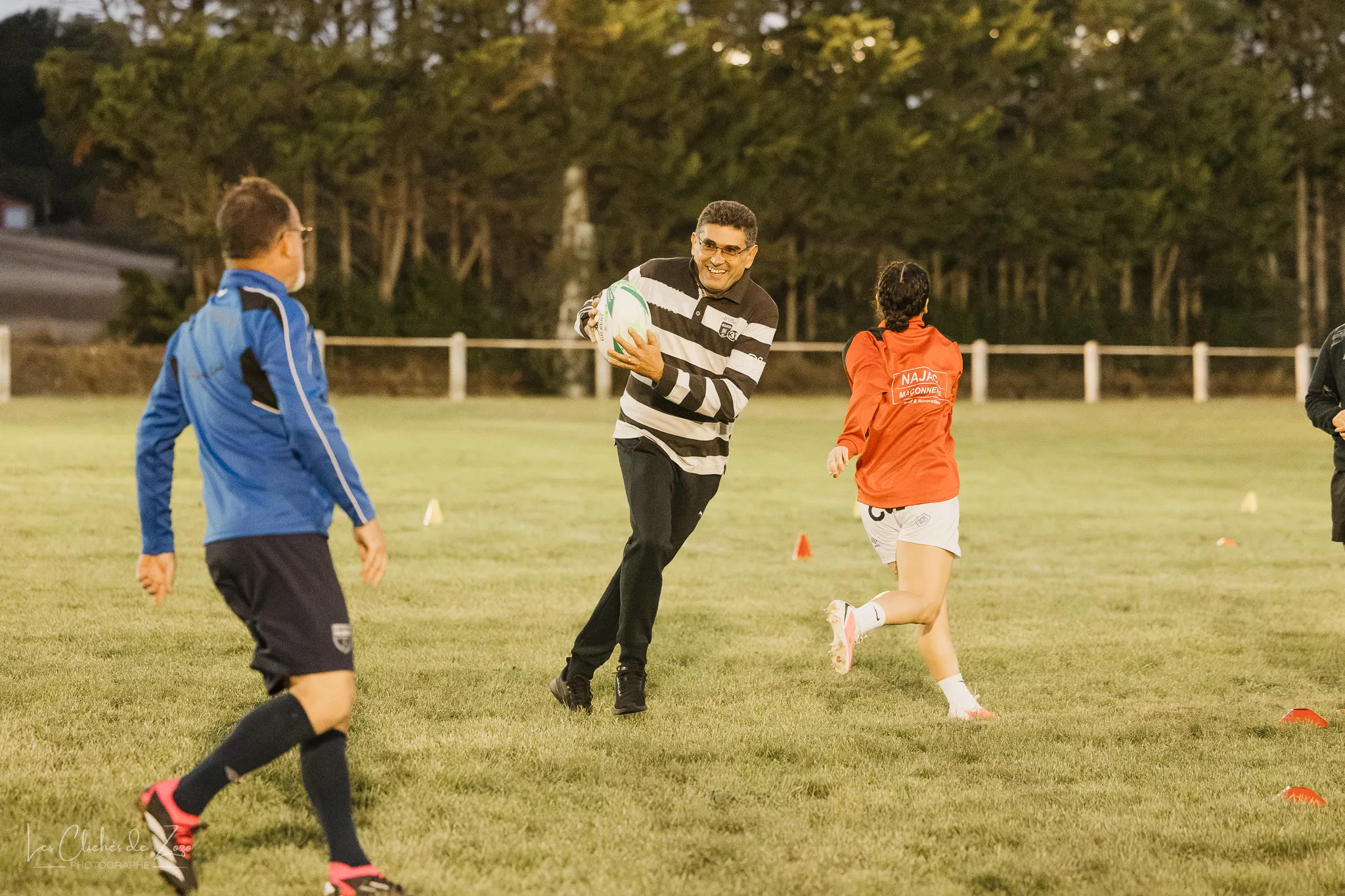 Un joueur sourit en courant avec le ballon